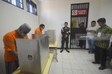 Tahanan memasukkan surat suara ketika menggunakan hak pilih di rumah tahanan Kejaksaan Tinggi (Kejati) Jawa Timur,  Surabaya, Rabu (27/6). Sebanyak 17 orang tahanan Kejati Jatim menggunakan hak pilihnya dalam Pilgub Jatim 2018. Antara Jatim/M Risyal Hidayat/zk/18