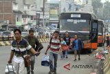 Sejumlah pemudik membawa barang bawaan di terminal bayangan, di jembatan layang Cibinong, Bogor, Jawa Barat, Minggu (10/6). Pemerintah mengimbau kepada pemudik untuk menghindari terminal bayangan, sebab sebagai salah satu penyebab kemacetan jalan dan di terminal bayangan banyak calo tiket yang membuat harga lebih mahal serta kurangnya kenyamanan dan keamanan bagi pemudik. ANTARA JABAR/Yulius Satria Wijaya/agr/18.