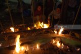 Pengunjung membakar jagung di Wisata Api Tak Kunjung Padam, Pamekasan, Jawa Timur, Minggu (24/6). Api alam tersebut menjadi destinasi wisata pengunjung dari berbagai daerah terutama saat musim liburan. Antara Jatim/Saiful Bahri/zk/18