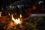 Pengunjung membakar jagung di Wisata Api Tak Kunjung Padam, Pamekasan, Jawa Timur, Minggu (24/6). Api alam tersebut menjadi destinasi wisata pengunjung dari berbagai daerah terutama saat musim liburan. Antara Jatim/Saiful Bahri/zk/18