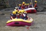 Sejumlah wisatawan memanfaatkan liburan dengan bertualang arung jeram atau rafting di aliran Sungai Ciliwung, Kali Baru, Bogor, Jawa Barat, Minggu (24/6). Wisata petualangan arung jeram di sungai yang dangkal tersebut sebagai salah satu wisata edukasi bagi anak sambil mengisi liburan. ANTARA JABAR/Yulius Satria Wijaya/agr/18.