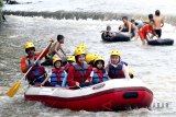 Sejumlah wisatawan memanfaatkan liburan dengan bertualang arung jeram atau rafting di aliran Sungai Ciliwung, Kali Baru, Bogor, Jawa Barat, Minggu (24/6). Wisata petualangan arung jeram di sungai yang dangkal tersebut sebagai salah satu wisata edukasi bagi anak sambil mengisi liburan. ANTARA JABAR/Yulius Satria Wijaya/agr/18.