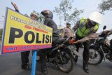 Polisi memeriksa lampu motor yang dikendarai warga saat Operasi Ketupat Semeru di Surabaya, Jawa Timur, Rabu (13/6). Pemeriksaan dan dilanjutkan dengan penggantian secara gratis lampu kendaraan bermotor yang mati itu untuk mengantisipasi dan meminimalisir kecelakaan lalu lintas terutama saat arus mudik. ANTARA FOTO/Didik Suhartono/kye/18