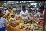 Umat Hindu menata sesajen saat ritual persembahyangan Hari Raya Kuningan di Pura Sakenan, Denpasar, Bali, Sabtu (9/6). Perayaan Hari Raya Kuningan yang merupakan rangkaian Hari Raya Galungan tersebut sebagai bentuk perayaan kemenangan 'Dharma' (kebaikan) melawan 'Adharma' (kejahatan). ANTARA FOTO/Wira Suryantala/wdy/2018