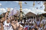 Warga berebut uang yang dibagikan saat Tradisi Mesuryak di Desa Bongan, Tabanan, Bali, Sabtu (9/6). Mesuryak merupakan tradisi berebut uang yang dibagikan secara bergiliran oleh warga desa di depan pintu masuk pekarangan rumah setiap Hari Raya Kuningan dan dipercaya dapat mengantarkan roh leluhur menuju ke alam Nirwana. ANTARA FOTO/Fikri Yusuf/wdy/2018