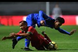 Pemain Timnas Indonesia U-23 Riko Simanjuntak (kiri) dijatuhkan pemain Timnas Thailand U-23 Chaiyawat Buran dalam pertandingan uji coba di Stadion Pakansari, Cibinong, Bogor, Jawa Barat, Minggu (3/6) malam. ANTARA FOTO/Sigid Kurniawan/foc/18.