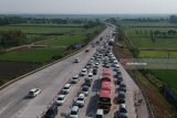 Foto aerial kendaraan terjebak kemacetan di pintu keluar tol Jombang-Mojokerto (Jomo) di Bandar Kedungmulyo, Jombang, Jawa Timur, Rabu (13/6). Dua hari menjelang lebaran, kemacetan terjadi di exit tol Jomo dari arah Surabaya menuju ke Madiun, hingga 1 kilometer. Antara Jatim/Syaiful Arif/zk/18