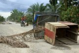 Pengendara motor melintas jalan Lintas Meulaboh-Tutut yang diblokir warga di Desa Meunasah Rambot, Kaway XVI, Aceh Barat, Aceh, Sabtu (30/6). Aksi pemblokiran jalan lintas sepanjang tiga kilometer tersebut sebagai protes terhadap pemerintah untuk segera melakukan pengaspalan karena warga di sepanjang jalan itu terkena gangguan kesehatan seperti Infeksi Saluran Pernapasan Akut (ISPA) akibat debu. (ANTARA FOTO/Syifa Yulinnas/Spt/18)