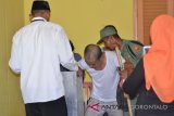 Petugas KPPS di TPS 3 Desa Molantadu Kecamatan Tomilito Kabupaten Gorontalo Utara memindahkan kotak suara untuk melayani pasien sakit sebanyak 4 orang di TPS itu. (Foto ; Shanty)