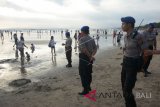 Polisi berjaga-jaga di kawasan Pantai Kuta, Bali, Sabtu (16/6). Polda Bali mengerahkan sedikitnya 1.400 personel yang terdiri dari TNI, Polri, Dinas Perhubungan, BPBD, Satpol PP, Pecalang dan Pramuka untuk memastikan pelaksanaan arus mudik, arus balik dan liburan Lebaran di Pulau Dewata berjalan aman dan lancar. ANTARA FOTO/Wira Suryantala/wdy/2018.