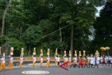 Sejumlah perempuan Bali menjunjung Gebogan atau sesajen bersusun buah, bunga dan hiasan janur dalam Tradisi Mapeed di Pura Alas Kedaton, Tabanan, Bali, Selasa (19/6). Tradisi tersebut merupakan rangkaian persembahyangan umat Hindu yang digelar setiap enam bulan sekali dengan melibatkan ratusan warga setempat. ANTARA FOTO/Wira Suryantala/wdy/2018