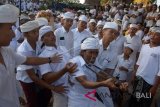 Seorang umat Hindu yang kesurupan menancapkan keris ke dadanya dalam tradisi 'Ngerebong' di Pura Dalem Pengrebongan, Denpasar, Minggu (17/6). Ritual berkeliling pura yang diwarnai puluhan umat kesurupan itu bermakna untuk menetralisir kekuatan negatif yang ada di alam. ANTARA FOTO/Wira Suryantala/wdy/2018.