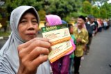 Warga menunjukkan kupon untuk mengambil zakat fitrah berupa beras di pendopo Sidoarjo, Jawa Timur, Rabu (13/6/2018). Sekitar 5.000 paket zakat fitrah dari pegawai kabupaten Sidoarjo tersebut diberikan kepada masyarakat yang membutuhkan menjelang hari raya Idulfitri. (ANTARA FOTO/Umarul Faruq) 