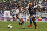 Pesepakbola Arema FC, Rivaldi Bawuo (kanan) dan pesepakbola Persela Lamongan, Ahmad Birrul Walidain (kiri) beradu cepat untuk menjangkau bola dalam pertandingan LIGA I GOJEK di Stadion Kanjuruhan, Malang, Jawa Timur, Sabtu (7/7). Arema mengalahkan Persela dengan skor 1-0. Antara Jatim/Ari Bowo Sucipto/zk/18.