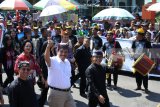 Menko Kemaritiman Luhut Binsar Panjaitan (kedua kiri) didampingi Bupati Banyuwangi Abdullah Azwar Anas (ketiga kiri) menyapa warga saat Banyuwangi Ethno Carnival ke-8 di Taman Blambangan, Banyuwangi, Jawa Timur, Minggu (29/7). Karnaval yang mengangkat tema Puter Kayun tersebut menampilkan sepuluh sub tema, yaitu Kupat Lepet, Tapekong, Oncor-oncoran, Keris, Buyut Jakso, Gedogan, Jaran (kuda), Dongkar (delman), Ejeg (kusir), dan Segoro (pantai) watu dodol. Antara Jatim/Seno/zk/18.