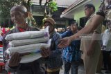 Petugas kecamatan membagikan beras pada keluarga pra sejahtera di Malang, Jawa Timur, Senin (16/8).  Sebanyak 6.819 KK yang terdiri dari keluarga pra sejahtera, penyandang disabilitas serta panti asuhan di kawasan tersebut mendapat bantuan berupa 10 kilogram beras setiap bulan. Antara Jatim/Ari Bowo Sucipto/zk/18.