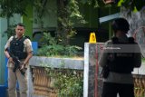Petugas kepolisian berjaga di sekitar lokasi ledakan bom di kawasan Pogar, Bangil, Pasuruan, Jawa Timur, Kamis (5/7). Ledakan yang diduga berasal dari ransel yang berisi bom tersebut melukai seorang anak berusia enam tahun. Antara Jatim/Umarul Faruq/mas/18.