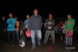 Sejumlah Pekerja Migran Indonesia (PMI) berbaris sebelum menjalani pendataan oleh BP3TKI saat tiba di Dinas Sosial Provinsi Kalbar, Rabu (25/7) malam. Sebanyak 68 PMI dipulangkan Malaysia melalui Pos Lintas Batas Negara (PLBN) Entikong, Kabupaten Sanggau karena masa berlaku paspor telah habis, tidak memiliki pekerjaan dan gaji tidak dibayar majikan. ANTARA FOTO/Reza Novriandi/jhw/18