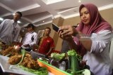 Peserta memotret makanan olahan berbahan khas Indonesia dalam Roadshow Cooking Class National Culinary Service Academy (NCSA) di Malang, Jawa Timur, Sabtu (28/7). Kegiatan  yang juga melibatkan Indonesian Chef Association (ACI) tersebut merupakan upaya untuk mengenalkan industri kuliner nusantara sebagai salah satu sektor pendongkrak pariwisata. Antara jatim/Ari Bowo Sucipto/zk/18.