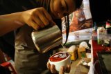 Barista (Peracik Kopi) menyeduh sajian kopi saat Festival Kopi Nusantara yang digelar di Aloon-Aloon Kanigoro, Blitar, Jawa Timur, Minggu (29/7). Festival yang dukung oleh Bank Indonesia (BI) dan diikuti sebanyak 27 kedai kopi serta barista se-Jatim tersebut bertujuan untuk mempromosikan produk kopi nusantara yang berasal dari sejumlah daerah seperti Aceh, Kalimantan, Bali, dan Papua. Antara Jatim/Irfan Anshori/zk/18