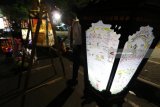 Pengunjung mengamati lampion bertema Cerita Panji di Simpang Lima Gumul, Kediri, Jawa Timur, Selasa (10/7) malam. Festival Lampion yang diikuti oleh perwakilan sekolah tingkat SMP dan SMA se-Kediri tersebut bertujuan memperkenalkan berbagai macam cerita panji kepada generasi muda. Antara Jatim/Prasetia Fauzani/mas/18.