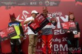 Bupati Banyuwangi Abdullah Azwar Anas (kedua kiri) menyerahkan hadiah juara pertama kepada atlet sepeda BMX Indonesia National Team putra I Gusti Bagus Saputra (kedua kanan) pada kejuaraan BMX Banyuwangi Internasional 2018 di Sirkuit Muncar, Banyuwangi, Jawa Timur, Minggu (15/7/2018). Pada final men elite round kedua kejuaraan tersebut diraih oleh atlet sepeda Indonesia National Team putra I Gusti Bagus Saputra, kemudian posisi kedua diraih GGMM Yesmart Swalayan Thrill BMX ISSI Kendal M Khabibur Rohman dan posisi ketiga atlet sepeda BMX Australia Kyle Green. (ANTARA FOTO/Zabur Karuru)