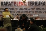 Petugas KPU memperlihatkan isi kotak surat suara saat Rapat Pleno terbuka rekapitulasi dan penetapan hasil penghitungan suara Pilgub Jatim di Surabaya, Jawa Timur, Sabtu (7/7). Dalam Rapat Pleno dan rekapitulasi tersebut KPU Daerah Jawa Timur menetapkan hasil penghitungan suara pada pemilihan Gubernur Jawa Timur dengan perolehan suara yakni 53,55 persen atau 10.465.218 suara untuk pasangan Khofifah Indar Parawansa-Emil Elestianto Dardak dan 46,45 persen atau 9.076.014 suara bagi pasangan Saifullah Yusuf-Puti Guntur Soekarno. Antara Jatim/Moch Asim/zk/18