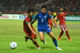 Pesepak bola Indonesia U-19  Hannis Saghara Putra (kiri) berebut bola dengan pesepak bola Thailand U-19 Kittitach Pranithi (tengah) dalam laga penyisihan grup A Piala AFF U19 di Gelora Delta Sidoarjo, Sidoarjo, Jawa Timur, Senin (9/7). Indonesia kalah atas Thailand dengan skor 1-2. Antara Jatim/Umarul Faruq/zk/18