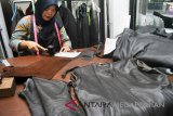 Pekerja mengerjakan perbaikan jaket kulit di Kalong Kulit Asli, jalan raya Cemplang Baru, Cilendek Barat, Kota Bogor, Jawa Barat, Rabu (18/7). Jasa perbaikan jaket kulit asli domba lokal Garut maupun domba impor tersebut setiap harinya mampu melayani sebanyak lima pesanan dengan harga mulai Rp.100 ribu hingga Rp.400 ribu tergantung ukuran dan tingkat perbaikan jaket dengan pelanggan dari wilayah Jabodetabek. (megapolitan.antaranews.com/Foto: Arif Firmansyah/18).