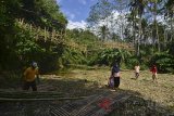 Warga membersihkan puing kayu sekaligus membuat jalur perlintas penyeberangan sementara pasca robohnya jembatan gantung di Desa Ciparay, Kecamatan Cidolog, Kabupaten Ciamis, Jawa Barat, Rabu (11/7). Sebanyak 15 orang warga mengalami luka akibat terjatuh saat melintasi jembatan yang terbuat dari bambu menggunakan kabel sling sepanjang 30 meter itu dan penyebab robohnya jembatan diduga karena kelebihan beban warga secara bersamaan melintasi untuk pergi ke acara undangan pernikahan. ANTARA JABAR/Adeng Bustomi/agr/18