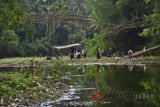 Warga membersihkan puing kayu sekaligus membuat jalur perlintas penyeberangan sementara pasca robohnya jembatan gantung di Desa Ciparay, Kecamatan Cidolog, Kabupaten Ciamis, Jawa Barat, Rabu (11/7). Sebanyak 15 orang warga mengalami luka akibat terjatuh saat melintasi jembatan yang terbuat dari bambu menggunakan kabel sling sepanjang 30 meter itu dan penyebab robohnya jembatan diduga karena kelebihan beban warga secara bersamaan melintasi untuk pergi ke acara undangan pernikahan. ANTARA JABAR/Adeng Bustomi/agr/18