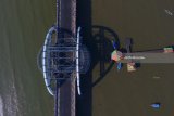 Foto aerial Jembatan Suroboyo yang terbentang di depan Taman Hiburan Pantai (THP) Kenjeran, Surabaya, Jawa Timur, Sabtu (7/7). Jembatan yang memiliki panjang sekitar 800 meter dan diresmikan pada 9 Juli 2016 lalu itu diharapkan dapat mengangkat potensi pariwisata kawasan pesisir dan mampu mengubah perekonomian nelayan di kawasan tersebut menjadi lebih baik. Antara Jatim/Didik Suhartono/zk/18