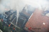 Petugas pemadam kebakaran memadamkan api yang membakar pemukiman padat penduduk di kawasan Braga, Bandung, Jawa Barat, Senin (9/7). Kebakaran tersebut menghanguskan puluhan rumah yang disebabkan dari ledakan gas elpiji warga. ANTARA JABAR/Heru Salim/agr/18.
