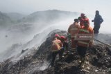 Petugas PMK berusaha memadamkan api yang membakar gunung sampah di TPA Supit Urang, Malang, Jawa Timur, Rabu (25/7). Kebakaran di TPA seluas 16 hektare tersebut mengakibatkan 4 kecamatan dilanda kabut asap dan diperkirakan baru bisa dipadamkan dalam lima hari karena kandungan gas metan. Antara jatim/Ari Bowo Sucipto/18.