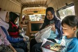 Warga membaca buku saat menaiki Angkot eksekutif  Angkutan Keliling Kota Bandung (Angklung) jurusan Ciwastra-Cijerah, Bandung, Jawa Barat, Kamis (5/7). Angkot eksekutif yang semula memiliki fasilitas AC, perpustakaan dan televisi dengan tarif dekat-jauh Rp. 7000 tersebut perlahan mulai mengurangi penggunaan fasilitas serta  mengubah tarif kembali normal sesuai jarak tempuh akibat semakin sedikitnya warga yang menggunakan fasilitas angkot angklung maupun angkot konvensional. ANTARA JABAR/Novrian Arbi/agr/18