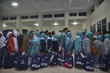 Antrean Jamaah calon haji sebelum masuk kedalam bus untuk diberangkatkan menuju Asrama Haji Embarkasi Bekasi di Gedung Dakwah, Kota Tasikmalaya, Jawa Barat, Senin (16/7) malam. Jamaah calon haji dari Kota Tasikmalaya yang berangkat tahun ini sebanyak 762 jamaah calon haji dibagi menjadi lima kali pemberangkatan atau lima kloter. ANTARA JABAR/Adeng Bustomi/agr/18