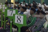 Sejumlah jamaah calon haji (JCH) Kloter pertama dari Kabupaten Situbondo mendengarkan arahan petugas  saat tiba di Asrama Haji Embarkasi Surabaya (AHES), Surabaya, Jawa Timur, Senin (16/7). Panitia Penyelenggara Ibadah Haji (PPIH) Embarkasi Surabaya menerima kedatangan 445 jamaah calon haji kelompok terbang (kloter) pertama dari Kabupaten Situbondo untuk dikaratina sebelum diberangkatkan ke Arab Saudi pada Selasa (17/7). Antara Jatim/Moch Asim/zk/18