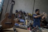 Pekerja menyelesaikan produksi ukulele di galeri Mahardika Instrument, Dago Pakar, Kabupaten Bandung, Jawa Barat, Senin (2/7). Asosiasi UMKM Indonesia mencatat, jumlah eksportir produk UMKM di Indonesia hanya mencapai angka lima Persen yang diakibatkan oleh biaya untuk mengekspor yang cenderung mahal. ANTARA JABAR/Raisan Al Farisi/agr/18