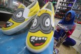 Pekerja menyelesaikan pembuatan sepatu lukis 