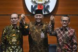 Ketua KPK Agus Rahardjo (tengah) bersama Ketua Komisi Yudisial Jaja Ahmad Jayus (kanan) dan Wakil Ketua KY Maradaman Harahap (kiri) saling bergandengan tangan saat memberikan keterangan pers usai penandatanganan nota kesepahaman di gedung KPK, Jakarta, Jumat (13/7/2018). KPK dan KY melakukan kerja sama dalam pemberantasan tindak pidana korupsi yang meliputi pertukaran data dan informasi, pencegahan tindak pidana korupsi, pendidikan, pelatihan dan sosialisasi, kajian dan penelitian, dan tenaga ahli. (ANTARA FOTO/Hafidz Mubarak A)