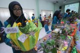 Mahasiswi STIE Perbanas Surabaya menunjukkan pot dari bahan kain handuk pada Super Softskills Mentoring 2018 di Surabaya, Jawa Timur (21/7). Sebanyak 1.500 pot dari bahan bekas karya sekitar 856 mahasiswa STIE Perbanas Surabaya dipamerkan dalam kegiatan itu dengan tujuan mahasiswa maupun masyarakat dapat memanfaatkan  barang bekas menjadi barang bernilai. Antara Jatim/Didik Suhartono/mas/18.