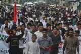 Santri peserta aksi jalan kaki menuju Jakarta meneriakkan yel-yel dukungan saat melintas Kota Tasikmalaya, Jawa Barat, Sabtu (21/7). Santri se-Pringan Timur, Jabar yang tergabung dalam Laskar Santri melakukan aksi berjalan kaki dari Kota Banjar menuju Jakarta, sebagai bentuk dukungan untuk Ketua Umum Partai Kebangkitan Bangsa (PKB) Muhaimin Iskandar atau Cak Imin menjadi cawapres 2019 berpasangan dengan Presiden Joko Widodo. ANTARA JABAR/Adeng Bustomi/agr/18