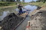 Pekerja memindahkan pasir dari perahu saat melakukan penambangan pasir dari dasar Sungai Citarum di Sapan, Kabupaten Bandung, Jawa Barat, Jumat (27/7). Menyusutnya Sungai Citarum saat musim kemarau dimanfaatkan warga untuk menambang pasir yang mereka jual Rp62.500 per kubik untuk keperluan bahan bangunan. ANTARA JABAR/Raisan Al Farisi/agr/18