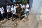 Menteri Badan Usaha Milik Negara (BUMN) Rini M Soemarno (kedua kanan) mengunjungi korban banjir bandang Desa Alasmalang, Singojuruh, Banyuwangi, Jawa Timur, Minggu (1/7). Dalam kunjungan kerjanya, Menteri BUMN menyempatkan mengunjungi korban banjir bandang dengan membungkus nasi bungkus, memberi semangat anak-anak korban banjir. Antara Jatim/Seno/zk/18.