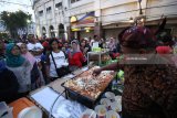 Pengunjung berbelanja makanan di salah satu stan kuliner khas Surabaya saat acara Mlaku-Mlaku Nang Tunjungan atau jalan-jalan ke Tunjungan di Surabaya, Jawa Timur, Sabtu (21/7). Kegiatan yang dimeriahkan dengan berbagai produk UKM dan kuliner khas Surabaya tersebut selain untuk menghidupkan kawasan Tunjungan sebagai salah satu kawasan bersejarah sekaligus untuk meningkatkan perekonomian para pelaku UKM serta mendongkrak jumlah kunjungan wisatawan. Antara Jatim/Moch Asim/18.