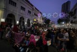 Pengunjung menikmati suasana malam saat acara Mlaku-Mlaku Nang Tunjungan atau jalan-jalan ke Tunjungan di Surabaya, Jawa Timur, Sabtu (21/7). Kegiatan yang dimeriahkan dengan berbagai produk UKM dan kuliner khas Surabaya tersebut selain untuk menghidupkan kawasan Tunjungan sebagai salah satu kawasan bersejarah sekaligus untuk meningkatkan perekonomian para pelaku UKM serta mendongkrak jumlah kunjungan wisatawan. Antara Jatim/Moch Asim/18.