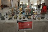 Pengunjung mengamati sejumlah piala penghargaan yang dipajang di Museum Surabaya, Jawa Timur, Kamis (5/7). Museum yang berada di Gedung Siola itu menyimpan berbagai benda bersejarah tentang kota Surabaya. Antara Jatim/Didik Suhartono/mas/18.