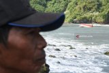 Warga melihat perahu nelayan yang tenggelam di perairan Plawangan Puger, Jember, Jawa Timur, Kamis (19/7). Sebanyak lima anak buah kapal (ABK) meninggal dunia, tujuh ABK hilang, sembilan ABK selamat akibat perahu tenggelam dihantam gelombang besar. Antara Jatim/Seno/18.