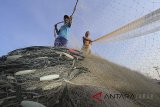 Nelayan menurunkan jaring dari perahu saat tidak melaut di Karangsong, Indramayu, Jawa Barat, Minggu (28/7). Ratusan nelayan di daerah tersebut tidak melaut sejak beberapa pekan terakhir akibat gelombang tinggi yang mencapai 5 meter di laut Jawa. ANTARA JABAR/Dedhez Anggara/agr18.