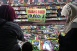 Warga memilih buku bacaan saat diselenggarakannya pasar rakyat di Desa Paron, Kediri, Jawa Timur, Selasa (10/7) malam. Sejumlah pedagang menyajikan ratusan judul buku bermutu dengan harga rata-rata Rp10.000 untuk tiga buku. Antara Jatim/Prasetia Fauzani/mas/18.